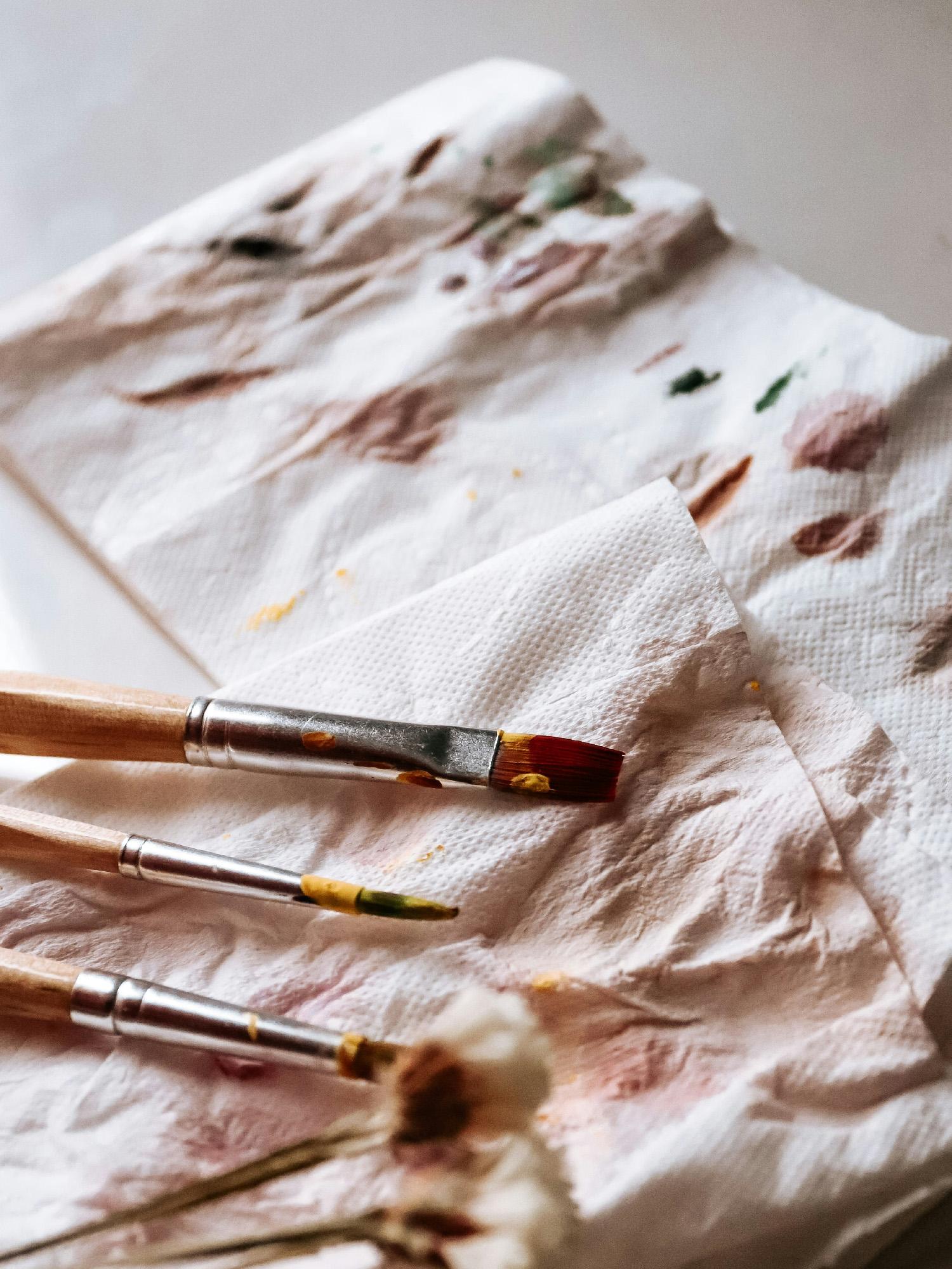 Freshly used brushes on top of some papers